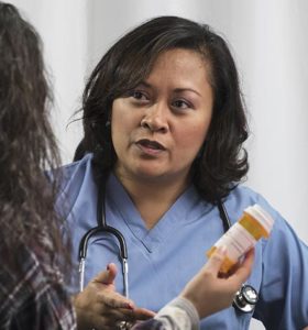 Nurse consulting with patient over pills. PHOTO: ADOBE STOCK