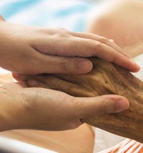 Nurse holding the hand of an elderly person