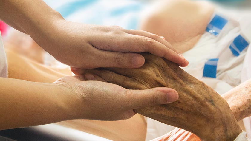 Nurse holding the hand of an elderly person