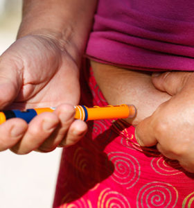 Person injecting insulin into their belly